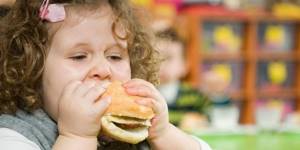 Девочка кушает гамбургер