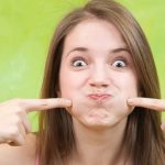 девушка надувает щеки