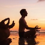 Мужчина и женщина в позе лотоса на закате