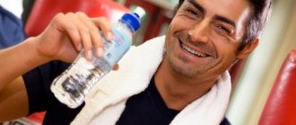 Спортсмен пьет воду на тренировке